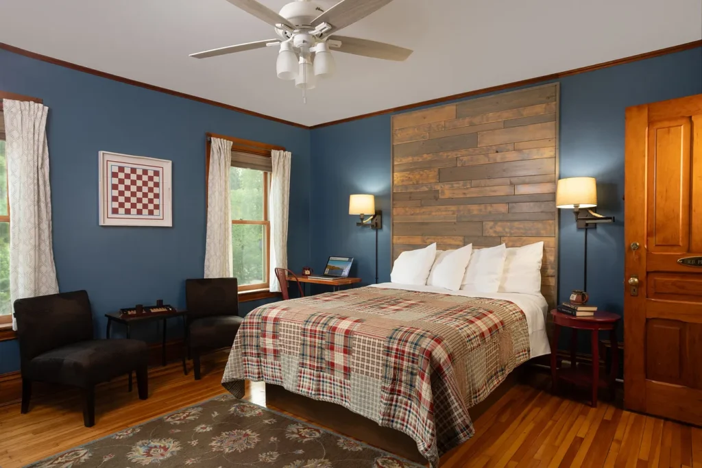 R.D. Pike Room: reclaimed-wood wall, plaid quilt and sitting chairs