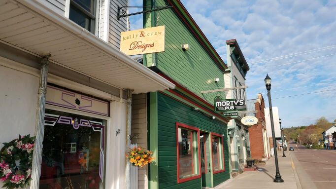 Morty's Pub green store front and Kelly's Crew white store front on Rittenhouse Avenue in Bayfield, WI